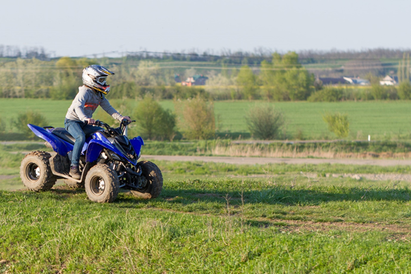 Child riding a quad bike on a grass field